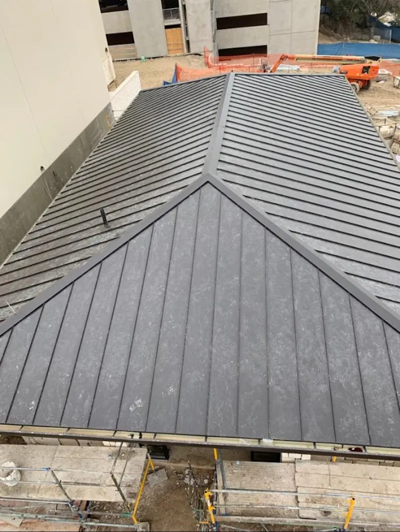 Commercial metal roof construction with crane equipment in Goshen